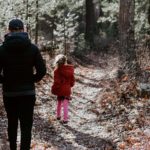 father walking in the woods with child