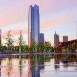 oklahoma city downtown in the background with a still body of water in the foreground