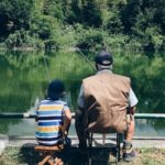 man and boy fishing in a pond