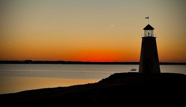 lighthouse on lake at sunset