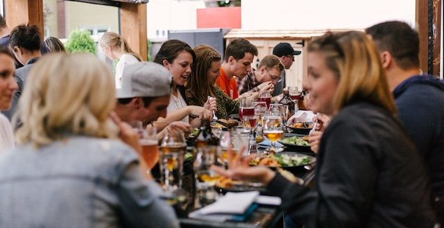 people eating at big table in restaurant