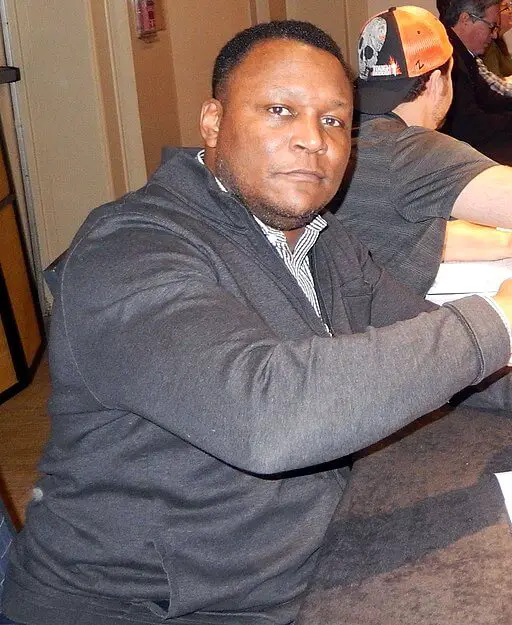 Barry Sanders in a suit looking at the camera