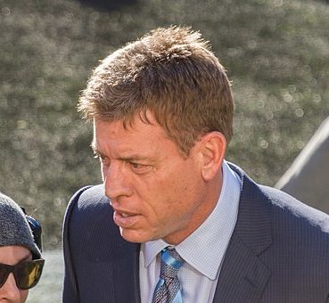 Troy Aikman standing next to someone