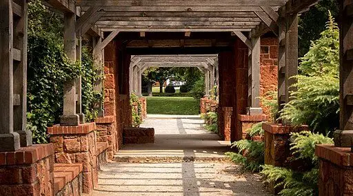 cement pathway with brick pillars and wooden rafters 