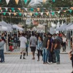 outdoor market with tents and people walking around