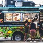food truck with 3 customers standing in front ordering food