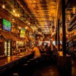 looking down a long bar with people eating and drinking