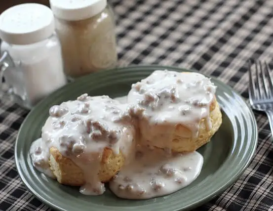 biscuits and gravy on a plate sitting on a table