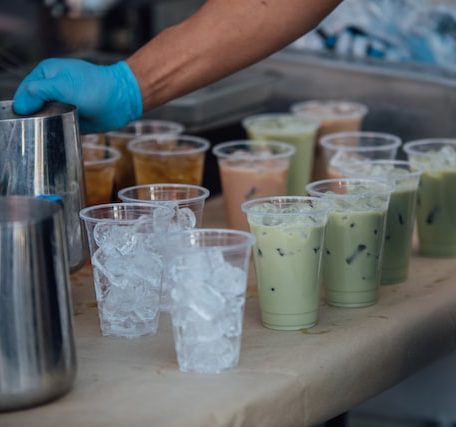 counter with about a dozen drinks of boba being made