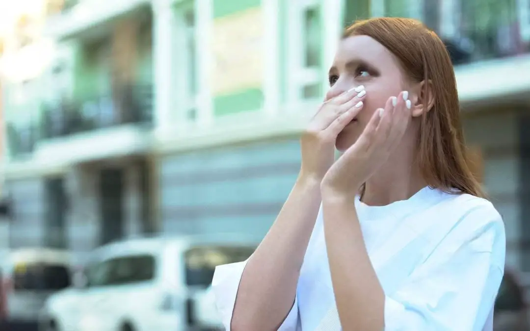 woman holding her nose