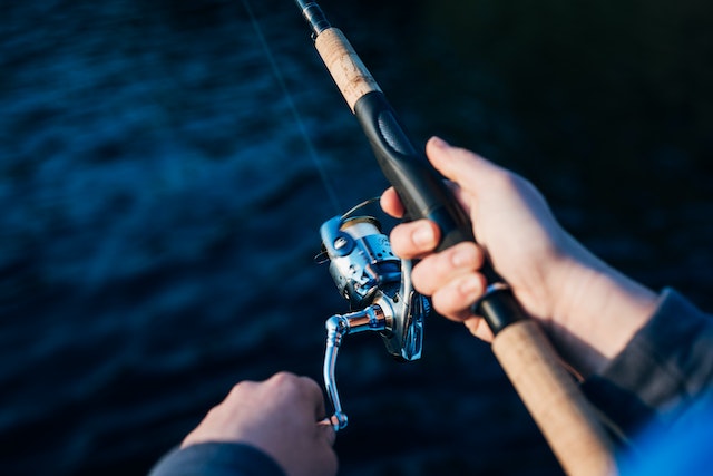 hands holding fishing rod and reel