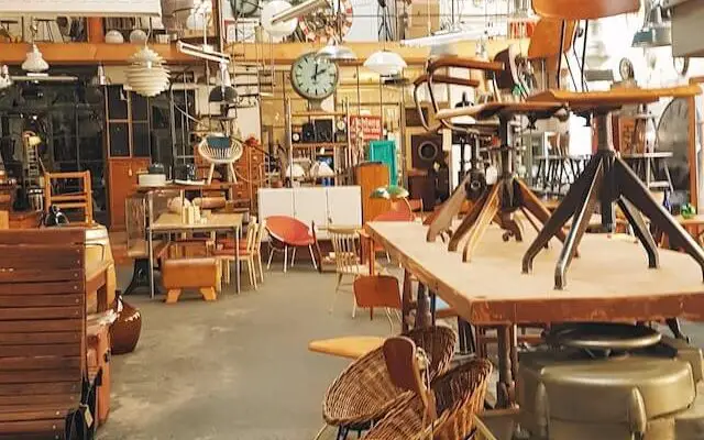 miscellaneous furnitre at a flea market, such as chairs and a bench