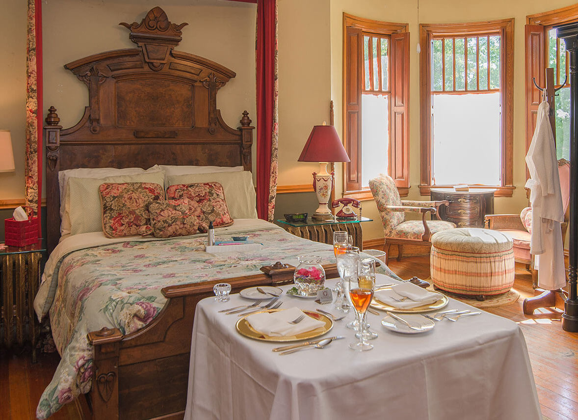 victorian style bedroom set with bed, nightstand, and a table with breakfast