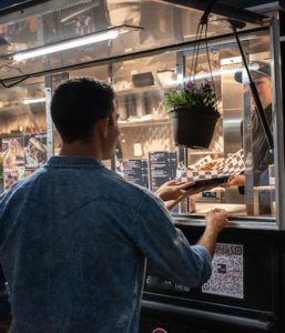 man getting food from a food truck