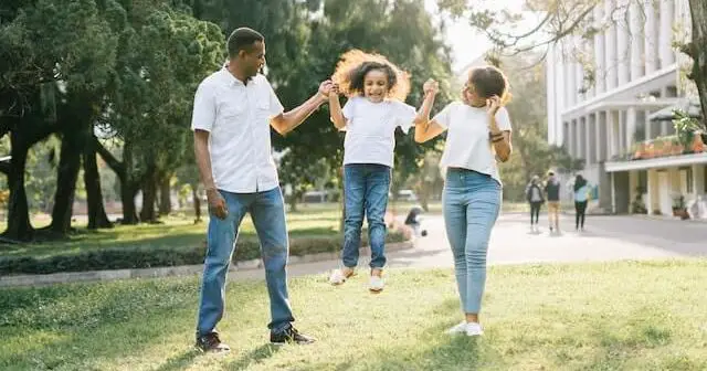 mom and dad lifting up girl