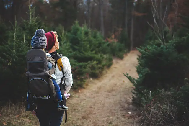 mother carrying child on back hiking