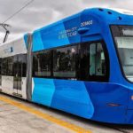 blue oklahoma city streetcar with the Devon tower in the background