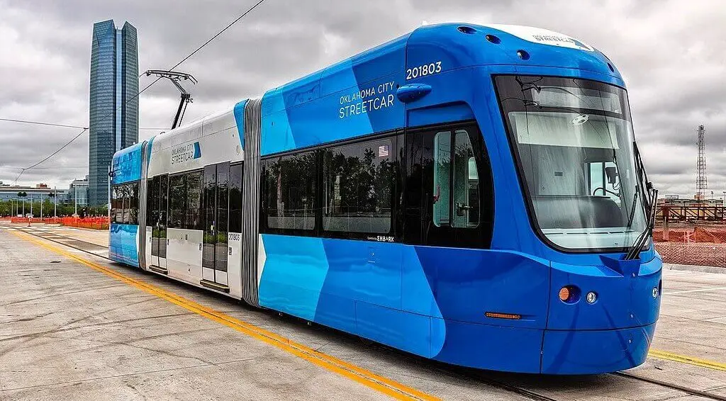 blue oklahoma city streetcar with the Devon tower in the background