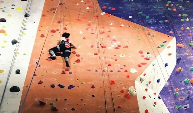 woman climbing indoor rock wall