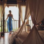 woman standing by window in luxury hotel room