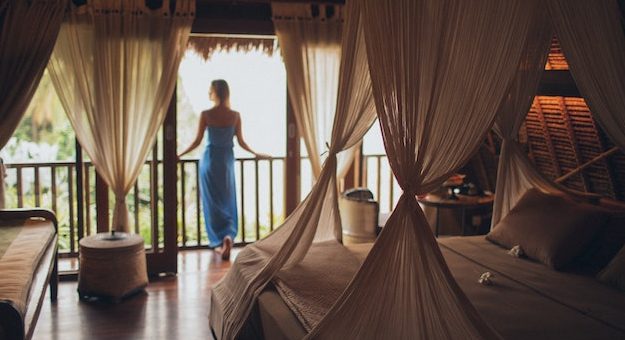 woman standing by window in luxury hotel room