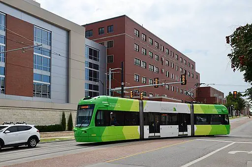 green Oklahoma City streetcar with buildings behind it