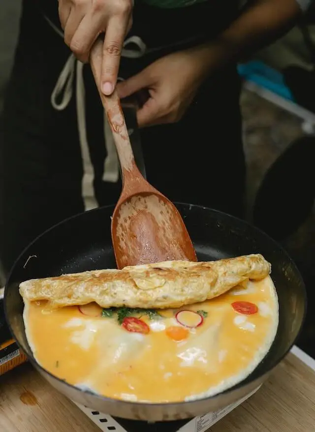 chef flipping an omelet in a pan