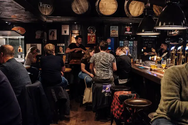 group of people talking and being social inside of a bar or pub