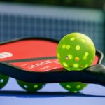 pickleball balls and paddle laying on court