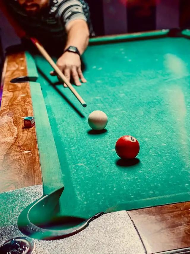 man shooting the red ball in a game of pool