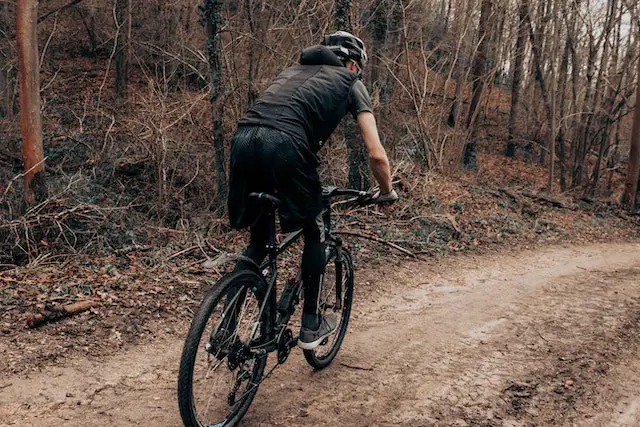man riding bike in woods