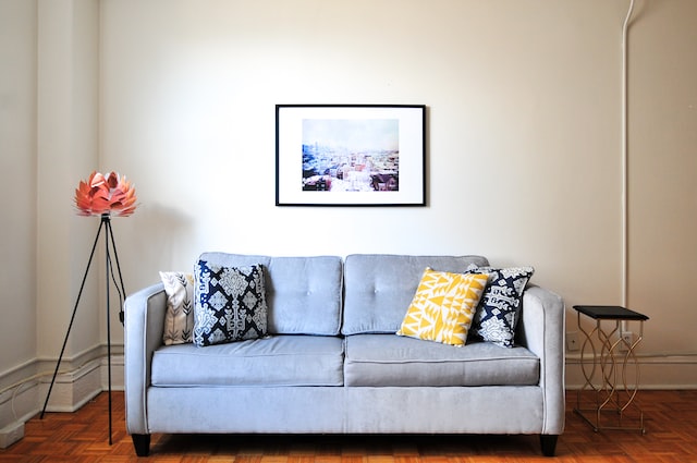 blue couch with pillows and wall decor