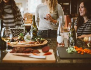 3 women eating and drinking wine together at a restaurant