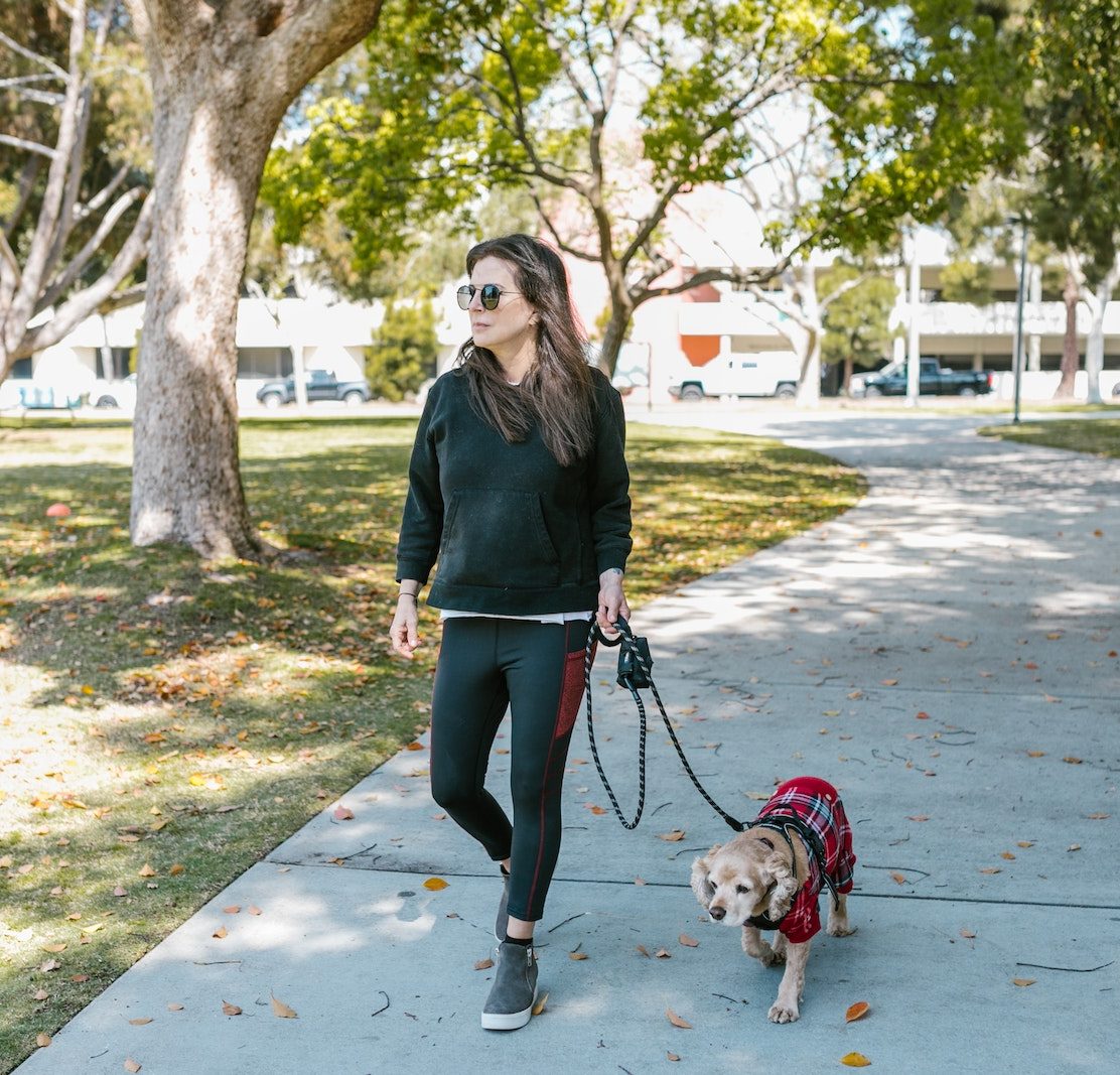 A Woman in Black Hoodie Walking with Her Dog