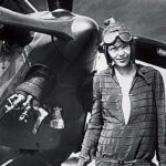 amelia earhart standing in front of an airplane