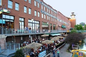 brick building and lots of people eating at restaurants all around