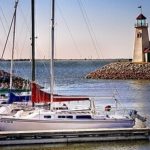 sailboats and a lighthouse at a lake