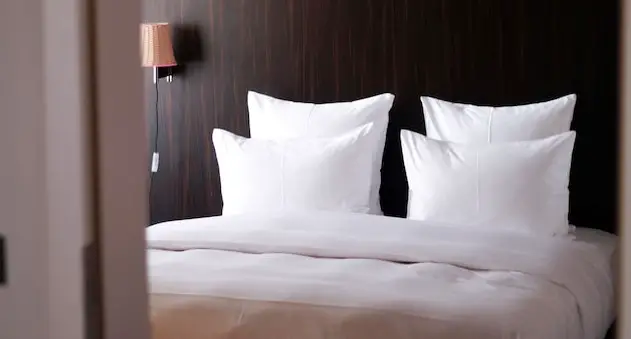 hotel bed with pillows and lamp