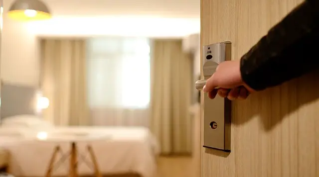 someone opening the door to a hotel room