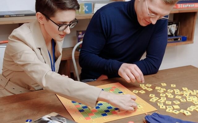 man and woman playing board game