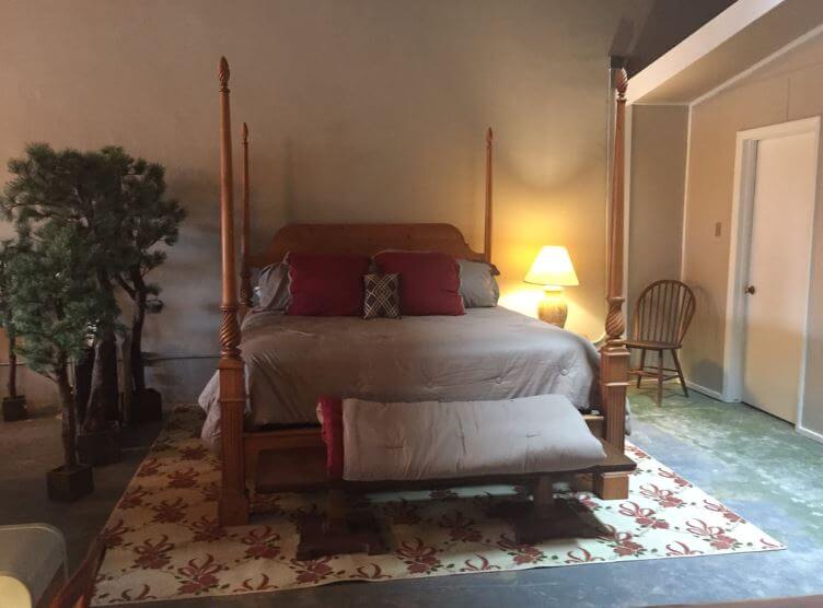 bed set with inside trees, chair, and lamp