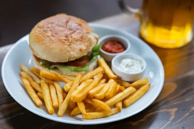 plate with burger and fries, and a beer