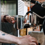 man making a latte with an espresso machine
