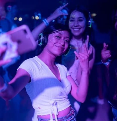 girl holding phone taking a photo of herself and her friends