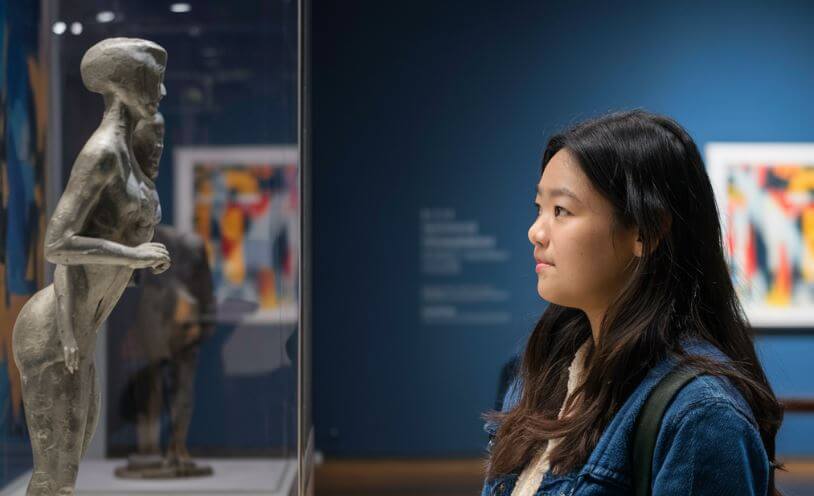 young woman looking at an art display at a museum