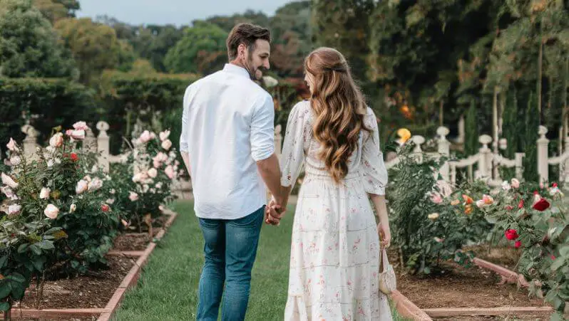 couple walking in a rose garden