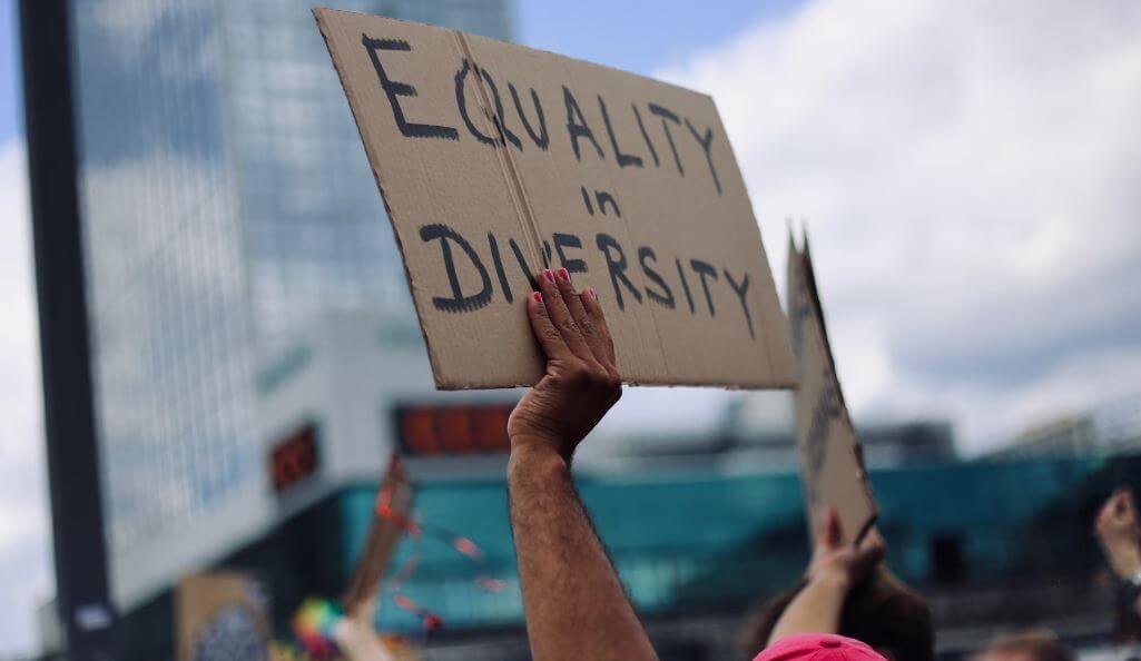 hands holding a sign that says "Equality in Diversity"
