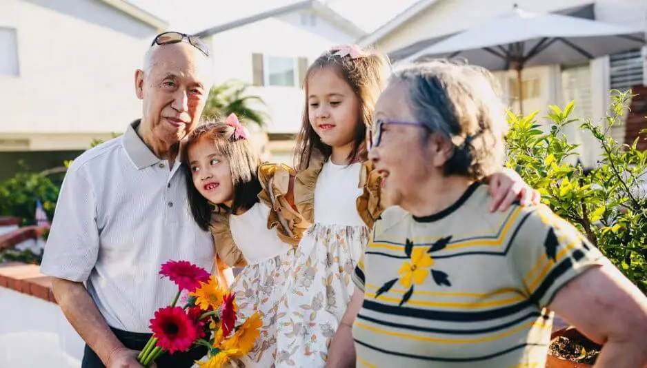 grandparents with their grandkids holding flowers