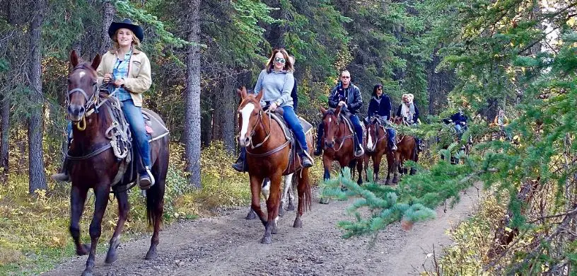 group riding horseback on a trail