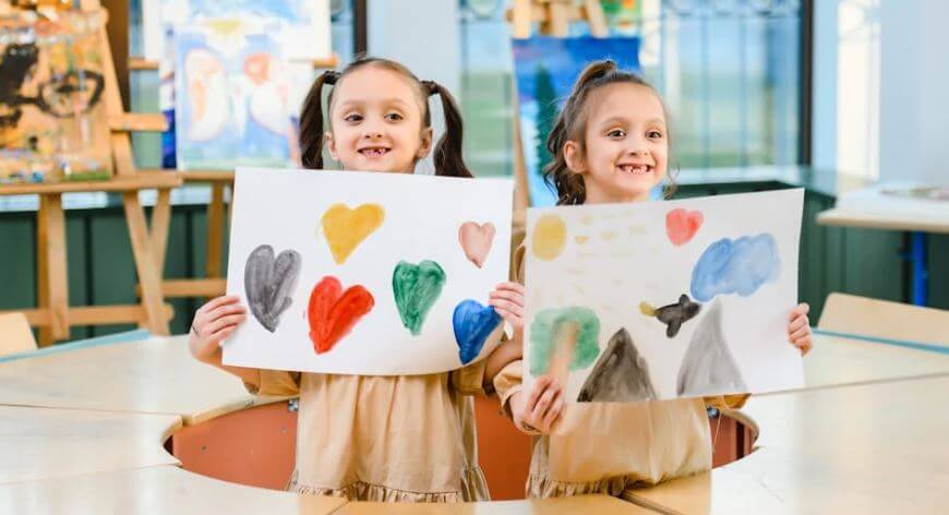 children holding up their art work